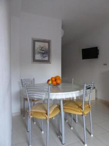 tavolo da pranzo con sedie e arance di Apartment Šimi - free parking a Supetar (San Pietro di Brazza)