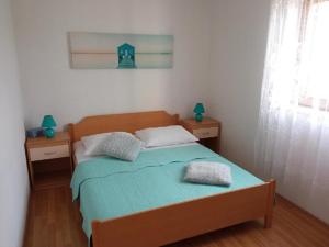 una camera con un letto con due cuscini sopra di Apartment Šimi - free parking a Supetar (San Pietro di Brazza)