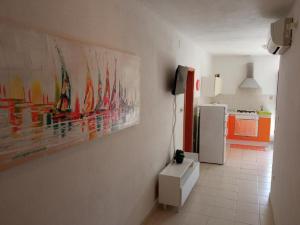 una cucina con un dipinto sul muro e un frigorifero di Apartment Šimi - free parking a Supetar (San Pietro di Brazza)