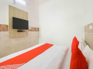 Schlafzimmer mit einem Bett und einem TV an der Wand in der Unterkunft Collection O 81235 Hotel Aashiyana in Neu-Delhi
