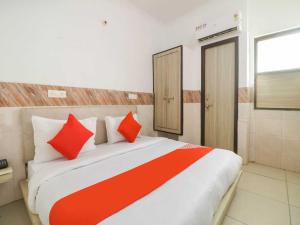a bedroom with a large bed with red pillows at Collection O 81235 Hotel Aashiyana in New Delhi