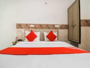a bedroom with a large bed with red pillows at Collection O 81235 Hotel Aashiyana in New Delhi