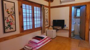 a living room with a chair and a television at Jeonju Hanok village Deoksugung in Jeonju