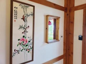 a painting of flowers on a wall with a window at Jeonju Hanok village Deoksugung in Jeonju