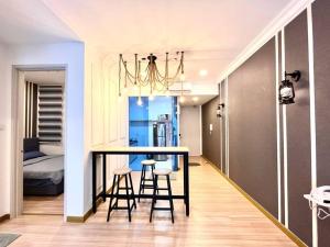 - une cuisine avec une table et deux tabourets dans une pièce dans l'établissement Grand Suite @ The Wave Residence-Cozy 2-BR Retreat: AC, Street Views & Games, à Malacca
