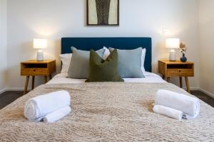 1 dormitorio con 1 cama con 2 toallas en The Tranquil Terrace - Zen zone 2 bed 2 bath, en Christchurch