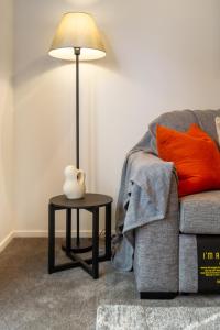 a lamp on a table next to a couch at The Tranquil Terrace - Zen zone 2 bed 2 bath in Christchurch