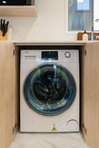 uma máquina de lavar e secar roupa branca numa cozinha em The Tranquil Terrace - Zen zone 2 bed 2 bath em Christchurch