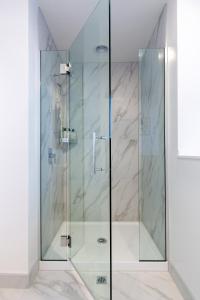 eine Dusche mit Glastür im Bad in der Unterkunft The Tranquil Terrace - Zen zone 2 bed 2 bath in Christchurch