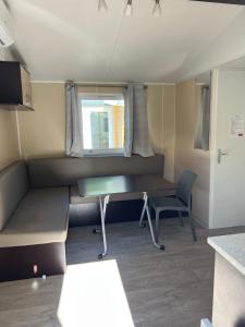 Habitación pequeña con escritorio y ventana. en Mobil-Home des Iscles, en La Roque-d'Anthéron
