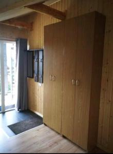 a room with wooden cabinets and a window at Dobilas ir jura in Palanga