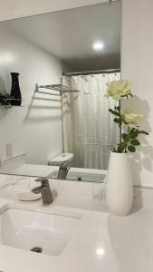 a bathroom with a white vase with a flower in it at Unit #204 Cozy Mountain View 2BR in Canmore Downtown in Canmore