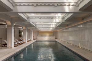 a swimming pool in a building with a large ceiling at Capella Sydney in Sydney