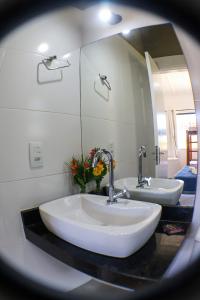 Un baño con dos lavabos y un espejo. en Pousada Mar'Tito Forno, en Búzios