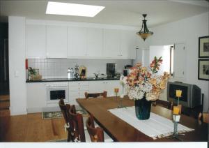 una cocina con una mesa con un jarrón de flores. en Casa Luís Gonzaga, en Bragança