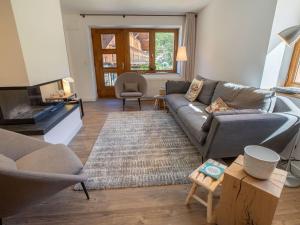 un salon avec un canapé et une télévision dans l'établissement Chalet rénové à Méribel · Cheminée · 4 chambres · Calme · Parking - FR-1-688-17, à Méribel