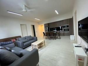 By The Sea - UBTS SMART ENTERPRISE في باتو فيرينغي: غرفة معيشة مع أريكة وطاولة