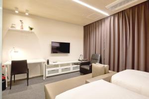 Pokój hotelowy z łóżkiem i biurkiem w obiekcie Grand City Hotel Changwon w mieście Changwon