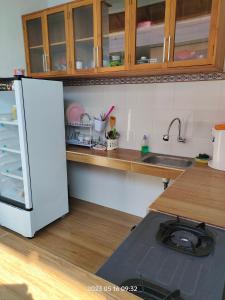 a kitchen with a white refrigerator and a sink at Konex homestay in Canggu