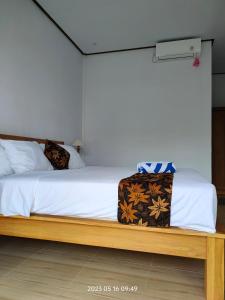 a bed with a suitcase sitting on top of it at Konex homestay in Canggu
