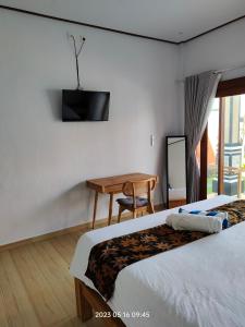 a hotel room with two beds and a table and a television at Konex homestay in Canggu