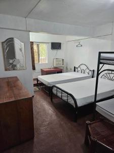 a room with two beds and a tv in it at Antipolo Budget Hostel,Family Rooms in Antipolo