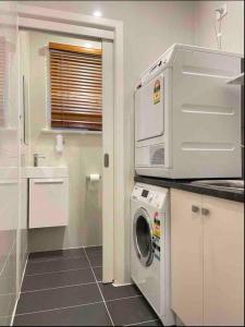 een keuken met een wasmachine bij Charming Family Home near Glen w AMAZING TEAHOUSE#MAR31 in Glen Waverley