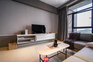 uma sala de estar com um sofá e uma televisão em Millerz Square Mana-Mana Suite em Kuala Lumpur