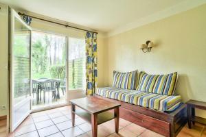 salon z kanapą i oknem w obiekcie Les Maisons du Domaine du Golf de Pinsolle - maeva Home - Maison 3 pièces 6 personnes - Sélection MAE-9964 w mieście Soustons