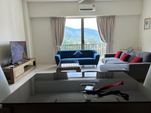 ein Wohnzimmer mit einem Sofa und einem Tisch in der Unterkunft By The Sea - UBTS SMART ENTERPRISE in Batu Feringgi