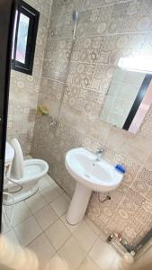 y baño con lavabo y aseo. en RAMS ENG ROME appartement meublé, en Douala