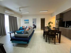 By The Sea - UBTS SMART ENTERPRISE في باتو فيرينغي: غرفة معيشة مع أريكة وغرفة طعام