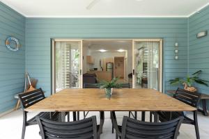 a dining room with a wooden table and chairs at Amphora Resort Private Apartments in Palm Cove