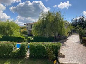 einen Garten mit Büschen und ein Gebäude und ein Haus in der Unterkunft Indigo Villas in Pismenovo