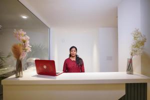 a woman standing behind a desk with a laptop at Inception Residence in Gurgaon