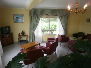 salon ze stołem i krzesłami oraz oknem w obiekcie Hotel La Costera w mieście A Lanzada