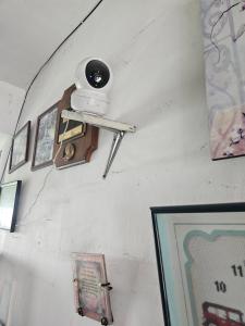 a white wall with a shelf and pictures on it at Antipolo Budget Hostel,Family Rooms in Antipolo
