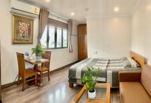 1 dormitorio con cama, mesa y sofá en căn hộ Lý Chính Thắng en Ho Chi Minh