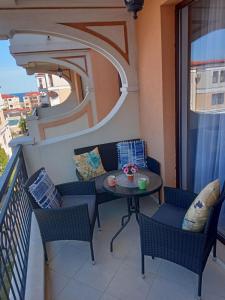 uma varanda com uma mesa e cadeiras. em Green Life Beach Resort Paradise Apartment em Sozopol