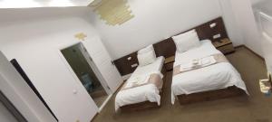 タシュケントにあるART RAKATのベッド2台と鏡が備わるホテルルームです。