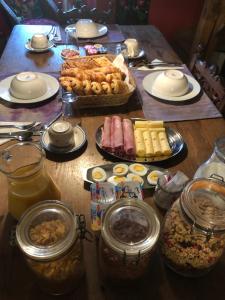 una mesa de madera cubierta con platos y tazones de comida en La forge b&b, en Perret