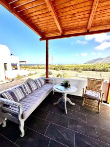 eine Couch auf einer Terrasse mit einem Tisch und Stühlen in der Unterkunft Aeron Suites in Éxo Goniá