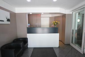 a waiting room with two chairs and a white counter at Carlton Hotel in Frankfurt/Main