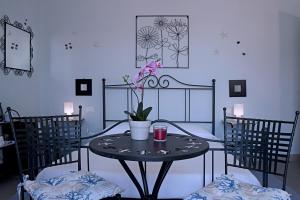 una mesa con un jarrón con dos sillas en La Casa Di Gabriella, en La Spezia