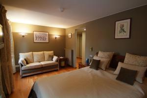 1 dormitorio con 1 cama grande y 1 sofá en La Roseraie. Gaume-Ardenne-lacuisine sur Semois., en Florenville
