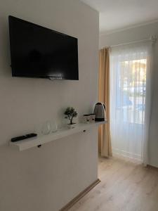 ein Wohnzimmer mit einem Flachbild-TV an der Wand in der Unterkunft Lemon-Ada Butik Otel in Kusadası