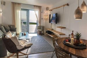 a living room with a couch and a table at Villa Elia by Mykonian Kazarte in Kalafatis