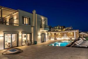 a large house with a swimming pool at night at Villa Elia by Mykonian Kazarte in Kalafatis