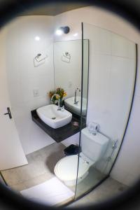 a bathroom with a toilet and a sink and a mirror at MarTito Forno Pousada - Armação dos Buzios in Búzios