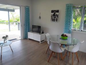 un salon avec une table en verre et une télévision dans l'établissement Absolute Beachfront - A Slice of Paradise!, à Rarotonga